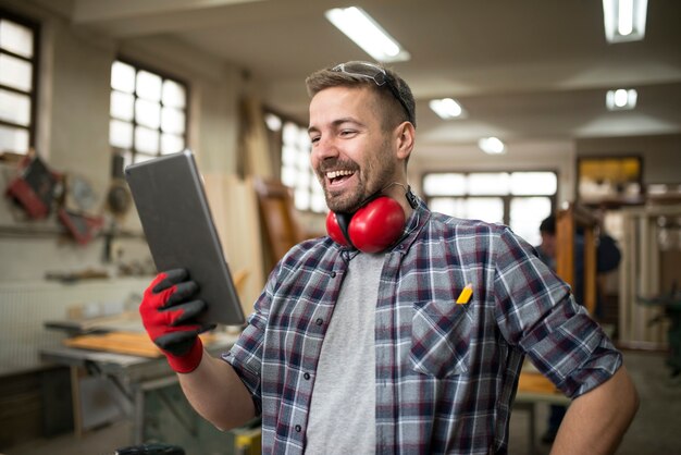 大工のワークショップでタブレットを使用してプロの木工職人