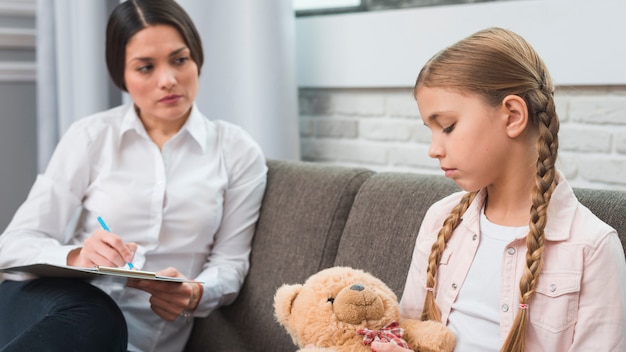 Professional young psychologist trying to get through to girl with problems