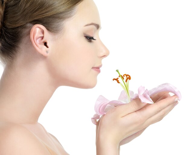 Profile of beautiful young girl smelling the flower