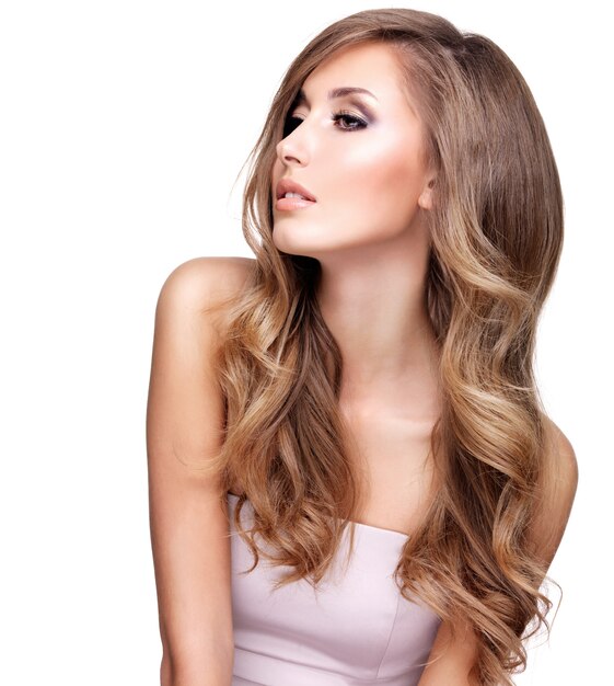 Profile of a beautiful young woman with long wavy hair and makeup