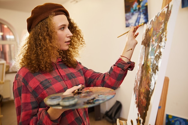 Profile of curly artist during her work