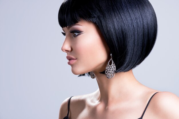 Profile portrait of a beautiful woman with shot hairstyle and fashion earring posing 