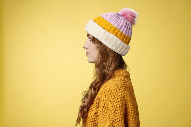 Profile shot attractive female curly hairstyle wearing hat knitted sweater standing queue order hot ...