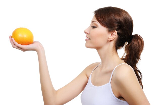 Profile of young beautiful woman with orange isolated
