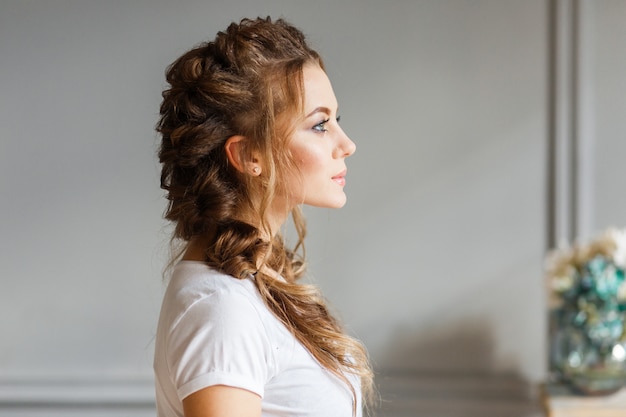 The profile of young beautifull girl on gray wall background.