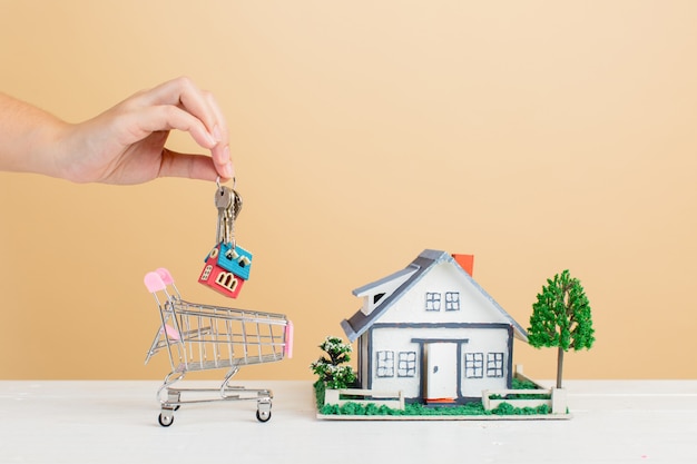 Free photo property market with house and  mini house in shopping cart