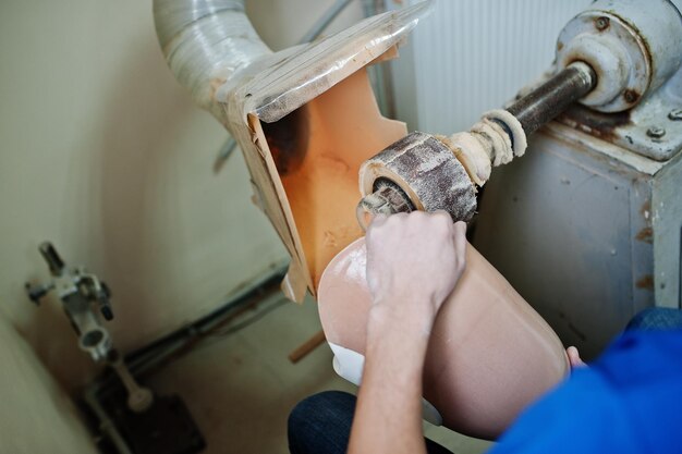 Prosthetist man making prosthetic leg while working in laboratory