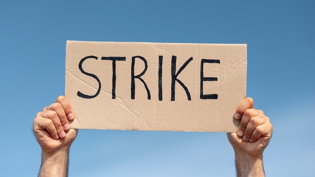 Free photo protester holding board with strike