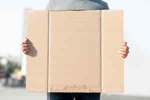 Free photo protester holding cardboard with mock-up