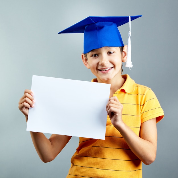 Free photo proud child holding a blank paper