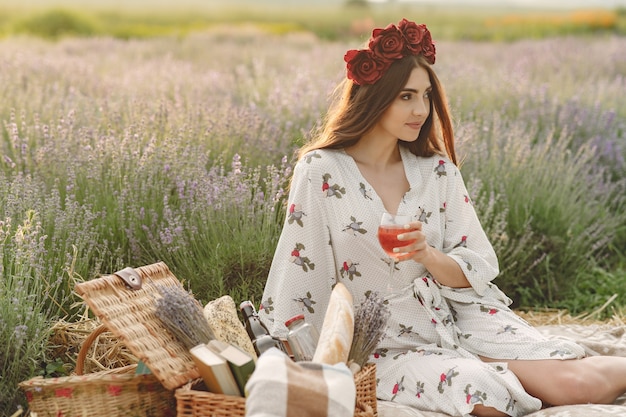 無料写真 ラベンダー畑でリラックスしたプロヴァンスの女性。ピクニックの女性。花の花輪の女性。