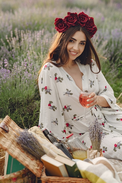 Free photo provence woman relaxing in lavender field. lady in a picnic. woman in a wreath of flowers.