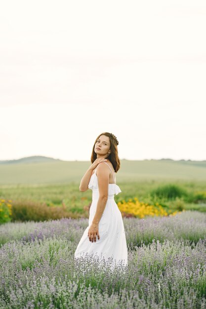 Provence woman relaxing in lavender field. Lady in a white dress. Girl with bag.