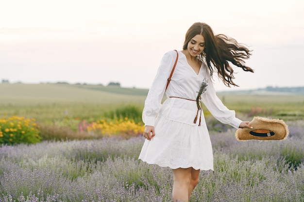 Foto gratuita provenza donna rilassante nel campo di lavanda. signora in abito bianco.