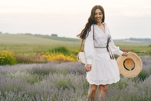 Provence woman relaxing in lavender field. Lady in a white dress.