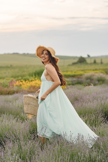 Provence woman relaxing in lavender field. Lady with a straw hat. Girl with bag.