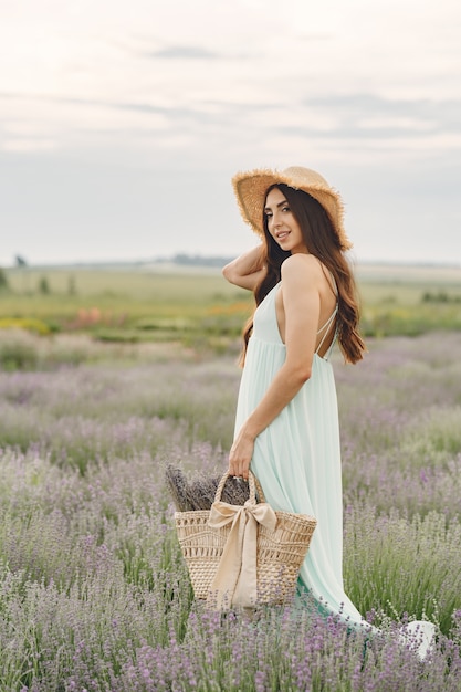 Provence woman relaxing in lavender field. Lady with a straw hat. Girl with bag.