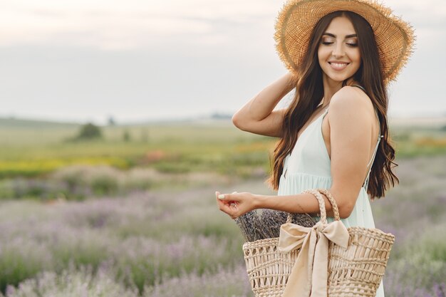 Provence woman relaxing in lavender field. Lady with a straw hat. Girl with bag.