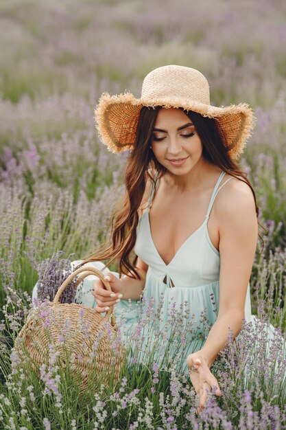 Provence woman relaxing in lavender field. Lady with a straw hat. Girl with bag.