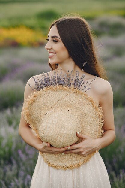 Provence woman relaxing in lavender field. Lady with a straw hat.