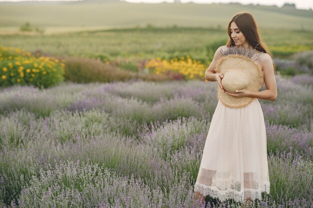 Provence woman relaxing in lavender field. Lady with a straw hat.