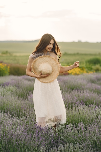 Provence woman relaxing in lavender field. Lady with a straw hat.