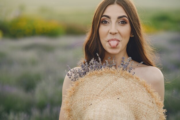 Provence woman relaxing in lavender field. Lady with a straw hat.