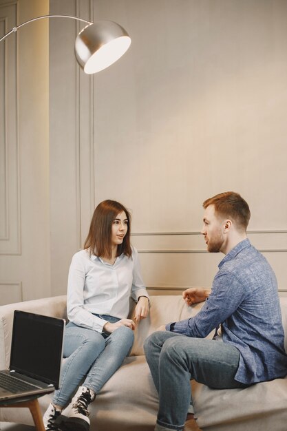 Pschycology and therapy. Woman is at the appointment with male pschycologist. Sitting on couch in modern cabinet.