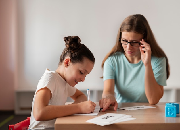 Psychologist helping a girl in speech therapy