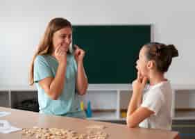 Free photo psychologist helping a girl in speech therapy