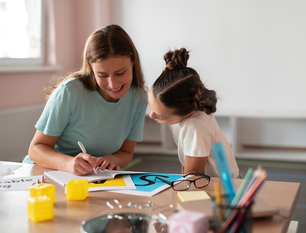 Free photo psychologist helping a little girl in speech therapy