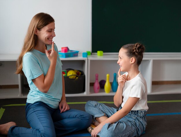 Psychologist helping a little girl in speech therapy