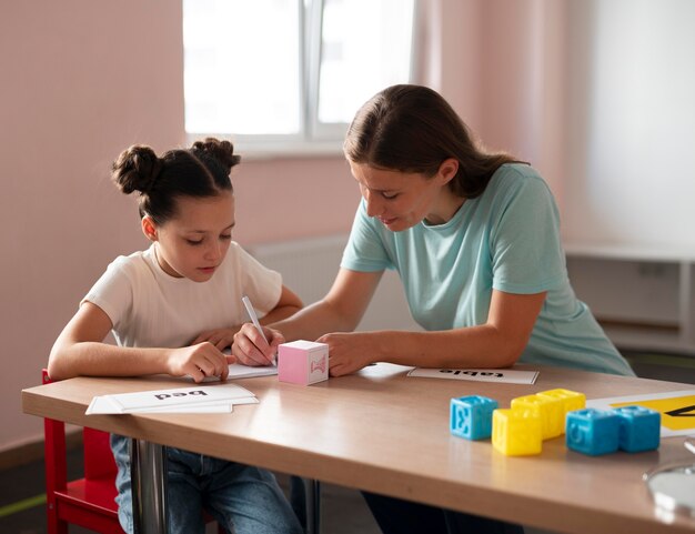 Psychologist helping a little girl in speech therapy