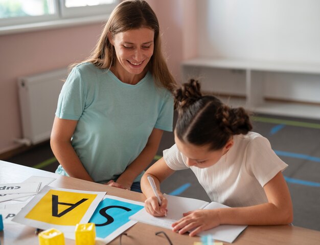 Psychologist helping a little girl in speech therapy