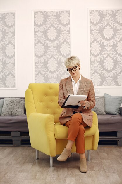 Psychologist with glasses sitting on a chair at the office