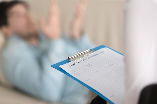 Psychologists office, female practitioner holding clipboard