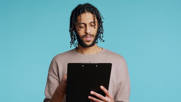 Public speaker reading from clipboard files studio background