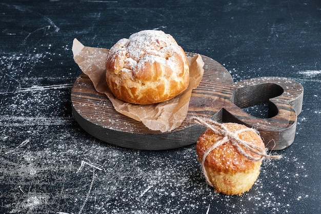 Foto gratuita panino di pasta sfoglia con cupcake su una tavola di legno.