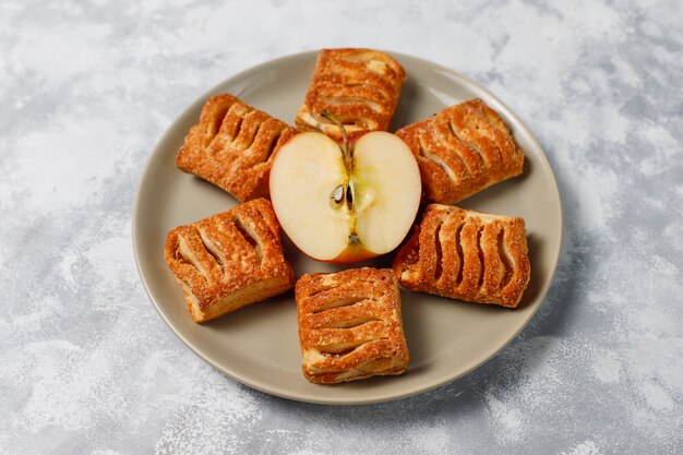 無料写真 アップルジャムと軽いコンクリートの新鮮な赤いリンゴで満たされたパイ生地のクッキー