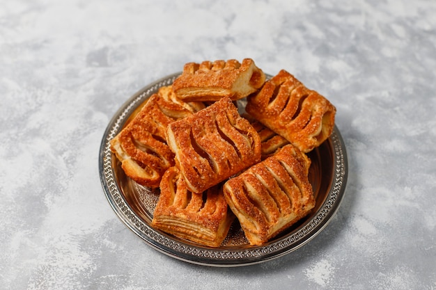 Puff pastry cookies filled with Apple jam and fresh red apples on light concrete 