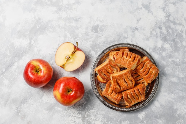 퍼프 페이스 트리 쿠키는 가벼운 콘크리트에 사과 잼과 신선한 빨간 사과로 가득