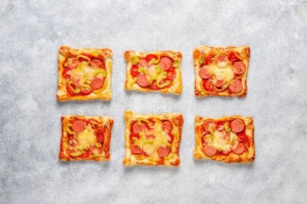 Мини-пиццы из слоеного теста с сосисками.