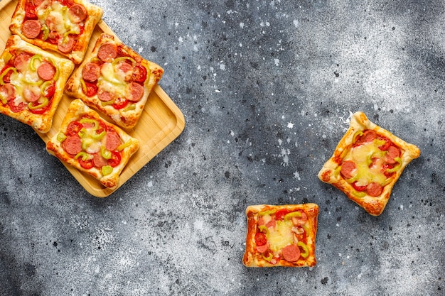 Puff pastry mini pizzas with sausages.