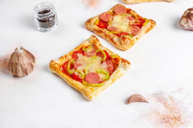 Puff pastry mini pizzas with sausages.