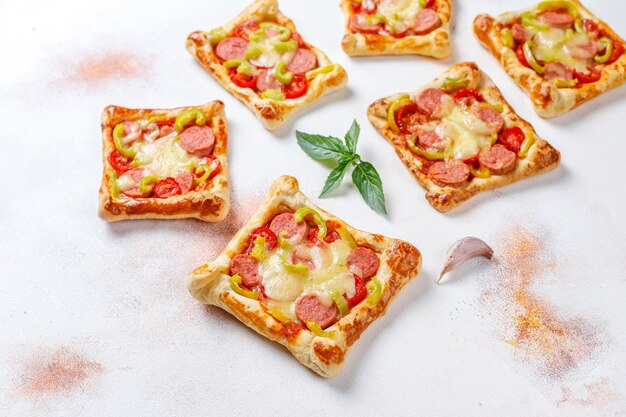 Puff pastry mini pizzas with sausages.