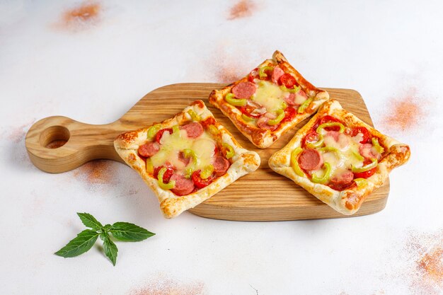 Puff pastry mini pizzas with sausages.