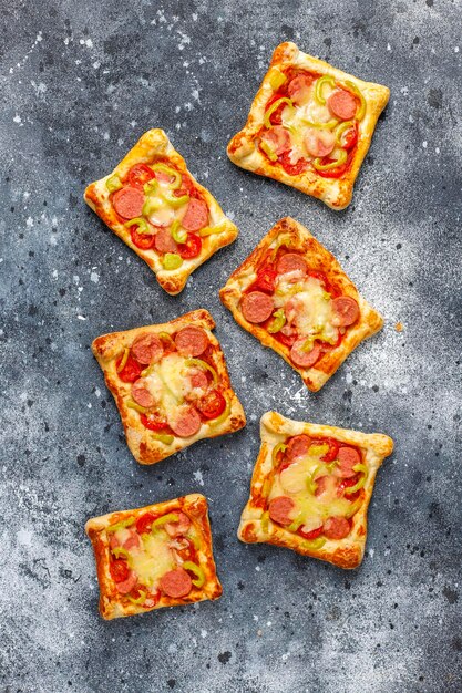 Puff pastry mini pizzas with sausages.
