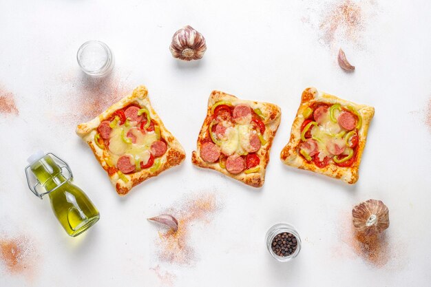 Pizzette di pasta sfoglia con salsiccia.