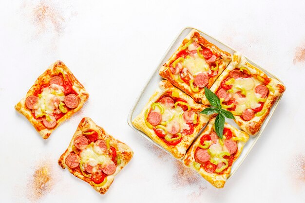 Puff pastry mini pizzas with sausages.