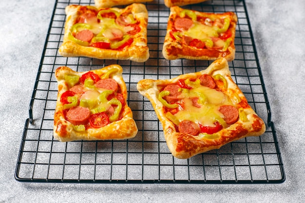 Puff pastry mini pizzas with sausages.